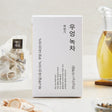 Myeongin Myeongchon Burdock and Green Tea Blend roasted by artisans in a hot pot at over 300°C, offering deep, fragrant notes. A smooth, balanced flavour merges burdock's savoury taste with green tea's astringency. Each box contains 10 tea bags. Steep in 300ml of 80–90°C water for 2 minutes for an ideal brew.