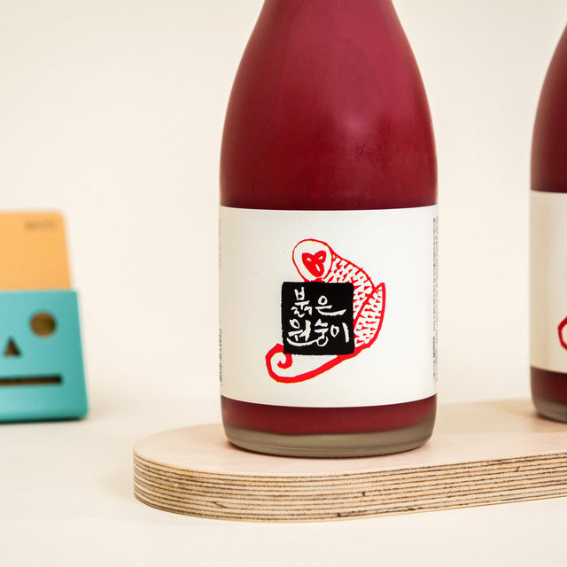 Sulseam Red Monkey Makgeolli, crafted in 2016, with a natural red hue from red yeast fermentation, offering a delicate sweetness and clean taste, ideal with light snacks.