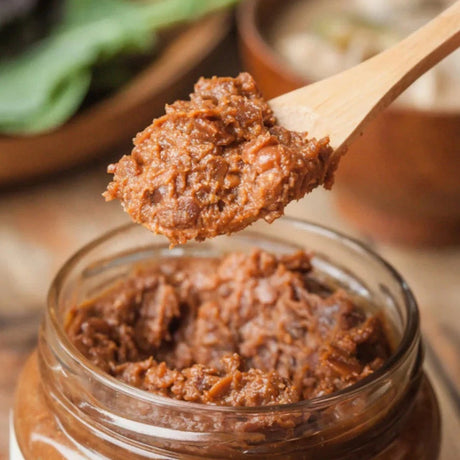 Artisanal Korean soybean paste crafted using the layered soybean paste method, with soy sauce extracted from the first fermentation and meju reintroduced for a second maturation. Aged in traditional pottery for 16 months, delivering a deep umami flavour perfect for enhancing dishes